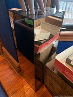 Full view of the mirrored pedestal stand showing the reflective surfaces and position next to boxes.