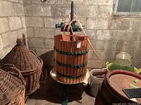 Overall front view showing wooden basket, metal bands, screw press mechanism and base.