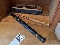 Black and natural wooden recorders shown on wooden surface with a MasSold lot tag.
