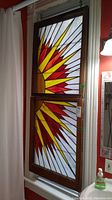 Two panels installed in window frame showing overall sunburst design