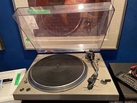 Turntable with dust cover raised showing platter and tonearm