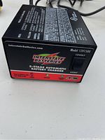 Front panel of the Interstate Batteries 5-Stage Automatic Battery Charger showing model number 12V1500 and 12 volts, with branding and LED indicators.