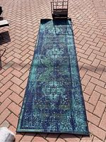 Full view of the blue-toned long runner rug laid flat on ground showing its length and pattern.