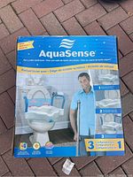 Front packaging of the AquaSense raised toilet seat showing product features and images.