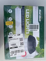 Top close-up of the box with branding including Solar Garden LED Lights, black garden lights, and pack details.