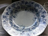 Top view of blue ceramic bowl with detailed blue rose pattern around the rim