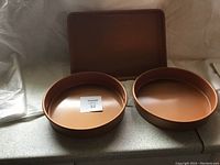 Photo showing three Gotham Steel pans with copper-colored non-stick interior, two deeper pans and one shallow pan.