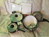 Overview of all items including two pots with lids, two frying pans, a metal skillet, and two wooden cutting boards.