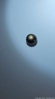 Close-up photo showing the 2.13ct round black star sapphire displaying a clear 6-ray star asterism on the cabochon surface under light.