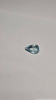 Image of a single deep sky blue pear shaped aquamarine gemstone shown on white background