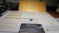 Photo of GRA certificate folder with laser inscribed moissanite gemstone and certification documents inside.