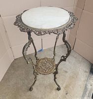 Front three-quarter view of brass stand with round faux marble top