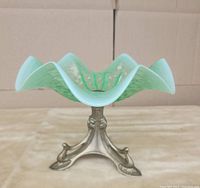 Front view of the green ruffled glass bowl on ornate brass base