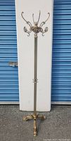 Full front view of brass floor coat rack showing overall design and condition