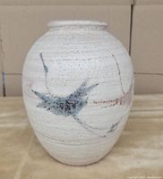 Front view of the vintage Japanese ceramic flower vase showing textured white glaze and blue bird design on the body.