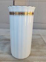 Front and side view of the Mikimoto Ichirinzashi Kabin Ikebana vase showing scalloped rim and gold band with colored dots.