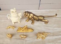 Lot arranged on table with large brass tiger and gold gilded zodiac animal figurines along with white composite vase with dragon designs