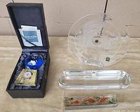 Five vintage Japanese crystal and glass items including a boxed Narumi polished blue globe with certificates, a long rectangular clear glass tray, an etched clear glass plate with a map, and a painted koi fish paperweight with visible chip.