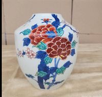 Front and side views of the vintage Japanese ceramic vase displaying hand painted colorful flowers and cherry blossoms on white ceramic.
