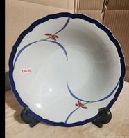 Front view of the large porcelain bowl with scalloped edges and orchid floral pattern.