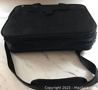 Side view of the computer bag showing the black nylon material and the shoulder strap with padding.