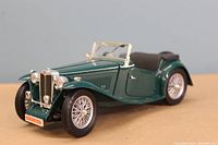 Front angle view of the 1947 MG TC Midget die cast model showing front grille, headlights, wheels and open convertible top.