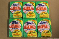 Front view of six unopened 1987 Topps Baseball wax packs showing promotional text and design.