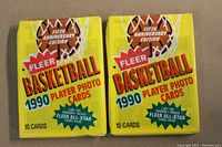 Two unopened yellow 1990 Fleer Basketball wax packs showing the front with text and branding.
