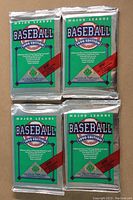 Front of four sealed 1990 Upper Deck Major League Baseball foil packs with green and silver packaging.