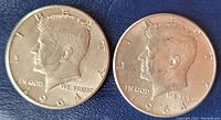 Two 1964 Kennedy half dollars showing the obverse side with Kennedy profile and text LIBERTY, IN GOD WE TRUST, dated 1964.