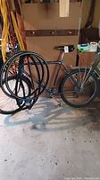 Black Trek bicycle with 21 inch frame leaning against a wall with tires visible