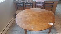 Full view of round teak table top and four chairs