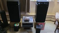 Front view of entire audio system including speakers, turntable, amplifier, DVD player, and records