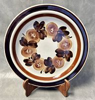 Front view of the 13-inch ceramic platter with brown and dark brown 'Anemone' floral design and rim bands.