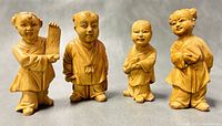 Front view of all four vintage Asian celluloid miniature kids figurines together showing their detailed facial features, poses, and clothing.