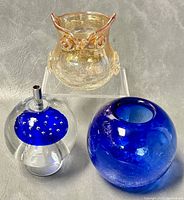 Photo showing all three glass pieces: iridescent owl creamer, cobalt blue rounded piece, clear glass mushroom with blue studded top and metal rod