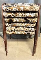 Stacked view of six vinyl stools showing printed seat cushions and metal legs.