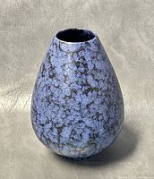 Front view of blue and black mottled textured ceramic vase with tear drop shape