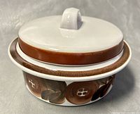 Top view of the covered vegetable dish showing the white lid with brown band and handle.