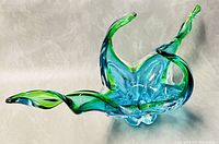 Side angle view showing the freeform structure with four arms extending outward and the green-blue Sommerso coloring.