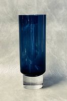 Full view of blue glass vase with clear glass base on a neutral background showing overall shape and color.