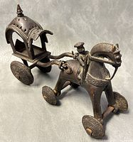 Front-side angle showing horse with rider and detailed carriage with ornate roof and wheels