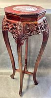 Front and side view of the old Chinese carved wood plant stand showing the carved floral apron, curved legs, and marble inset top.