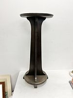 Front view of the wooden plant stand showing Gothic design and circular top.