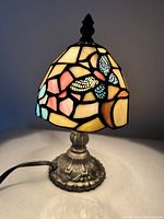 Lamp powered on showing the colorful stained glass illuminated with butterfly design.