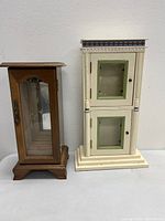 Pair of vintage wardrobe style jewelry boxes, one wooden with glass and one cream painted with decorative details