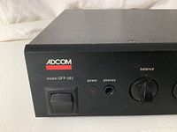 Front left detail showing ADCOM logo, model GFP-565 label, power switch, power LED, headphone jack and balance knob.