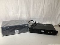 Denon AVR-2112CI AV receiver and Monster Power HTS3500 power conditioner side by side on table, both black with cables attached.