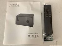 Owner’s manual and remote control sealed in plastic on white background