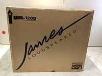 Front view of sealed cardboard box showing James Loudspeaker logo and EMB-1200 energy-multiplied bandpass subwoofer branding